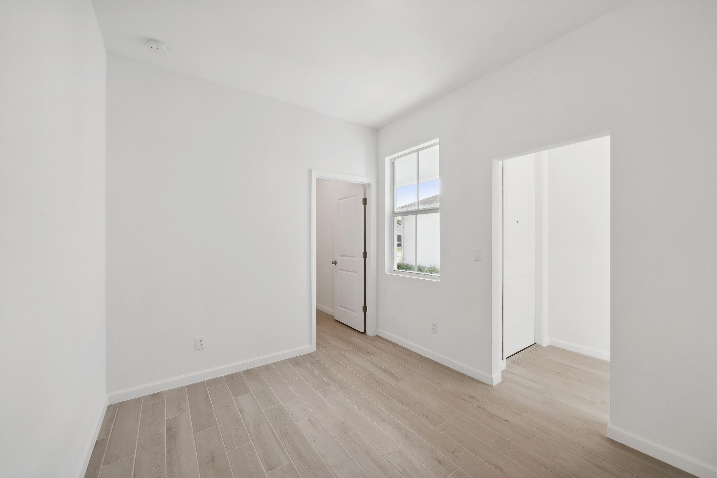 10099 Dreamweaver Road, Unit 51 Port St. Lucie, FL 34987 - Photo 4 of 36 a view of an empty room with wooden floor