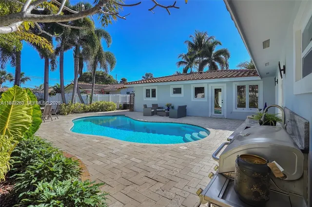 a view of a house with a swimming pool and sitting area