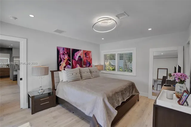 a bedroom with a large bed and a large mirror