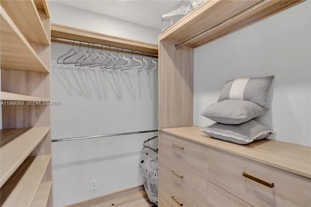 a bedroom with a bed and a potted plant on the dresser