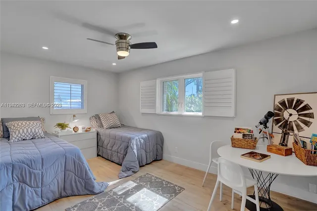 a bedroom with two beds and a desk