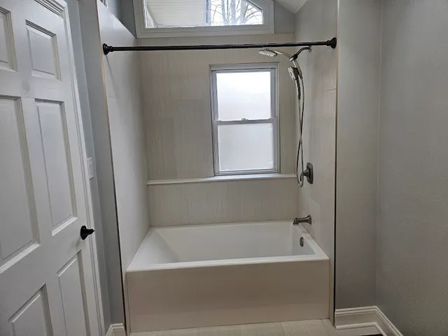 a white bath tub with a shower