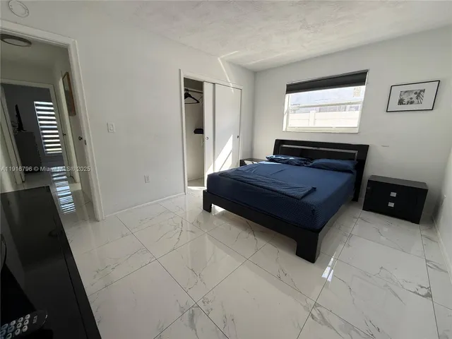 a bedroom with a bed and a tv on the dresser