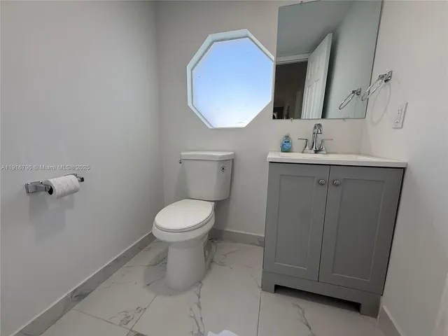 a bathroom with a toilet a sink and mirror