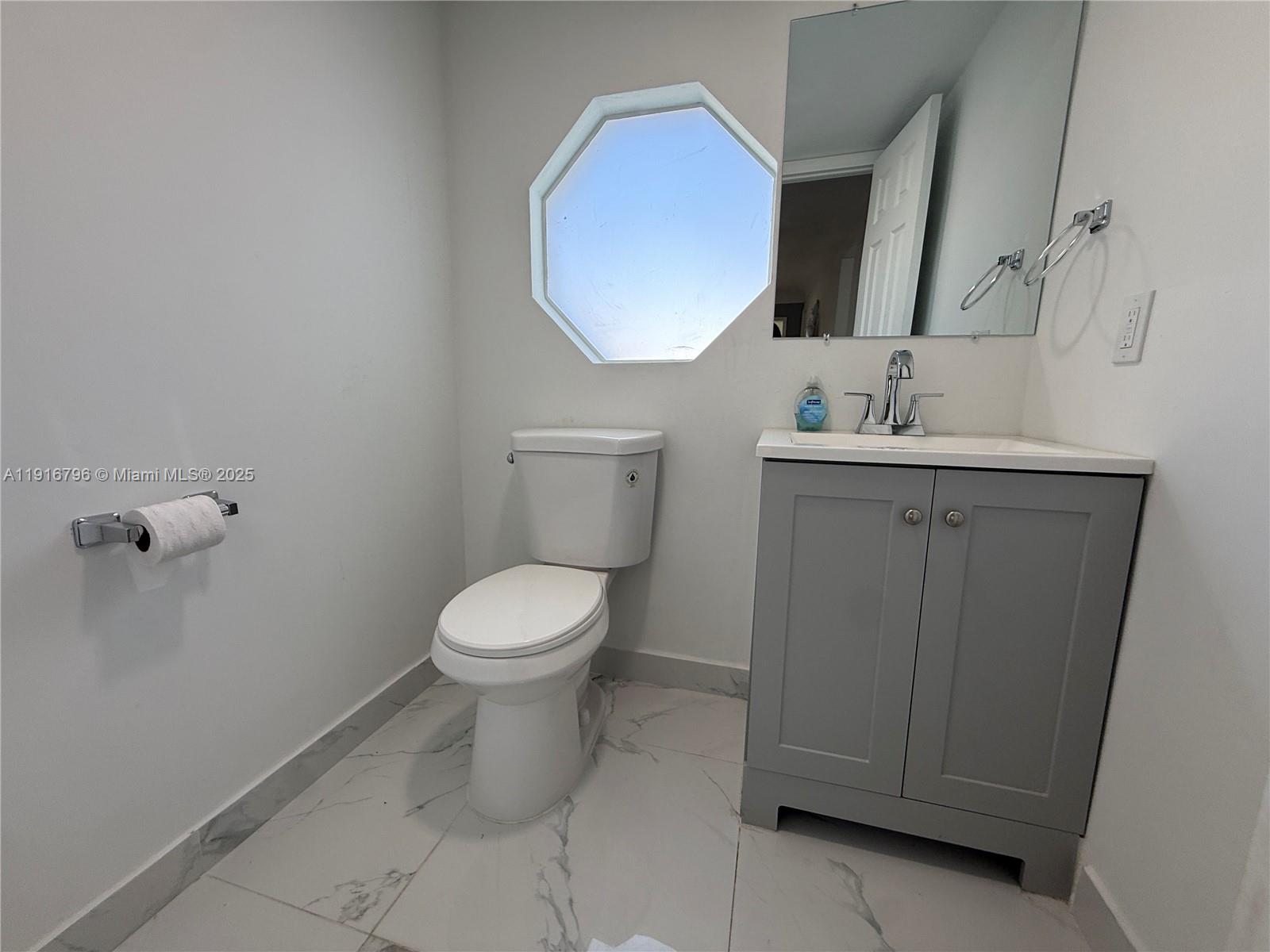 8636 Beekman Drive, Unit 8636 Miramar, FL 33025 - Photo 15 of 18 a bathroom with a toilet a sink and mirror