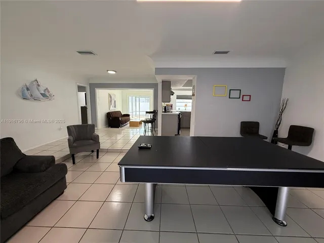 a living room with a table chairs and a open a window