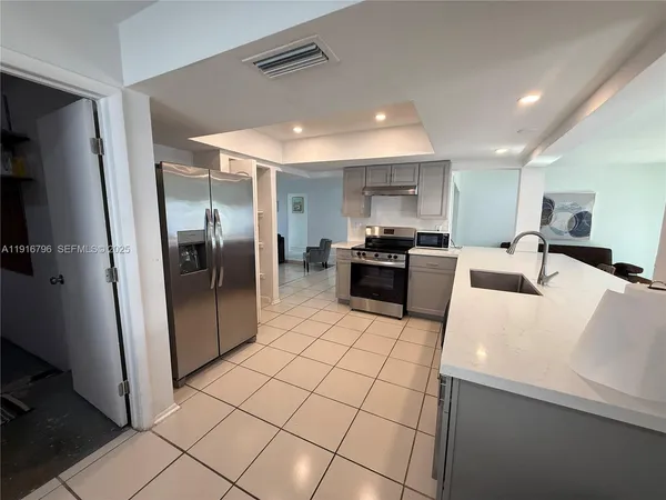 a kitchen with stainless steel appliances a refrigerator and a stove top oven