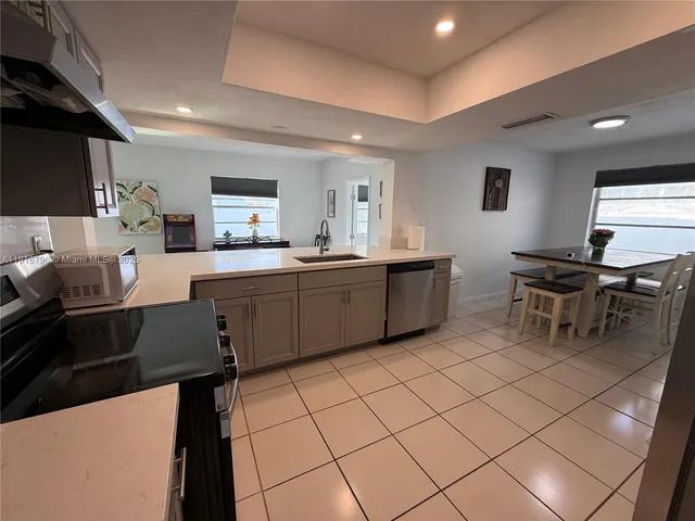 a kitchen with a sink and chairs