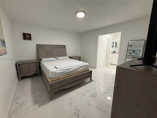 a bedroom with a bed and a television