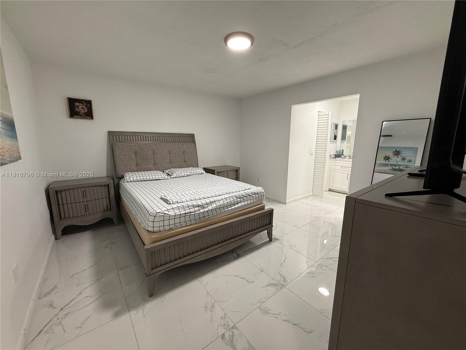 8636 Beekman Drive, Unit 8636 Miramar, FL 33025 - Photo 8 of 18 a bedroom with a bed and a television