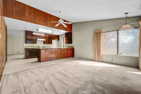 a view of a kitchen with a sink and an empty room