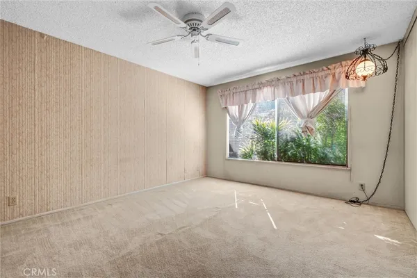 an empty room with windows and fan