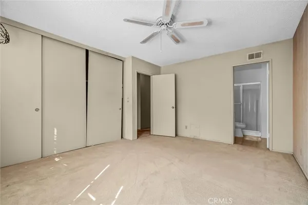 a view of an empty room with a ceiling fan