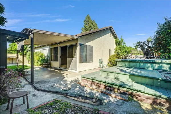 a view of a house with backyard and sitting area