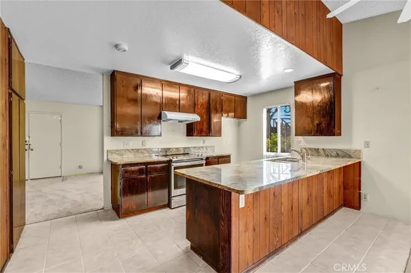 a kitchen with stainless steel appliances granite countertop a sink stove and cabinets