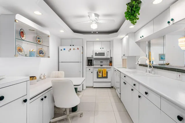 a white kitchen with a stove a refrigerator and a stove