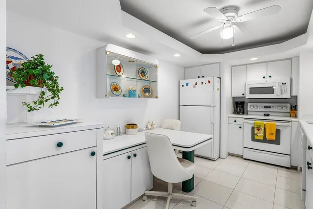 a kitchen with stainless steel appliances kitchen island granite countertop a table chairs and a refrigerator
