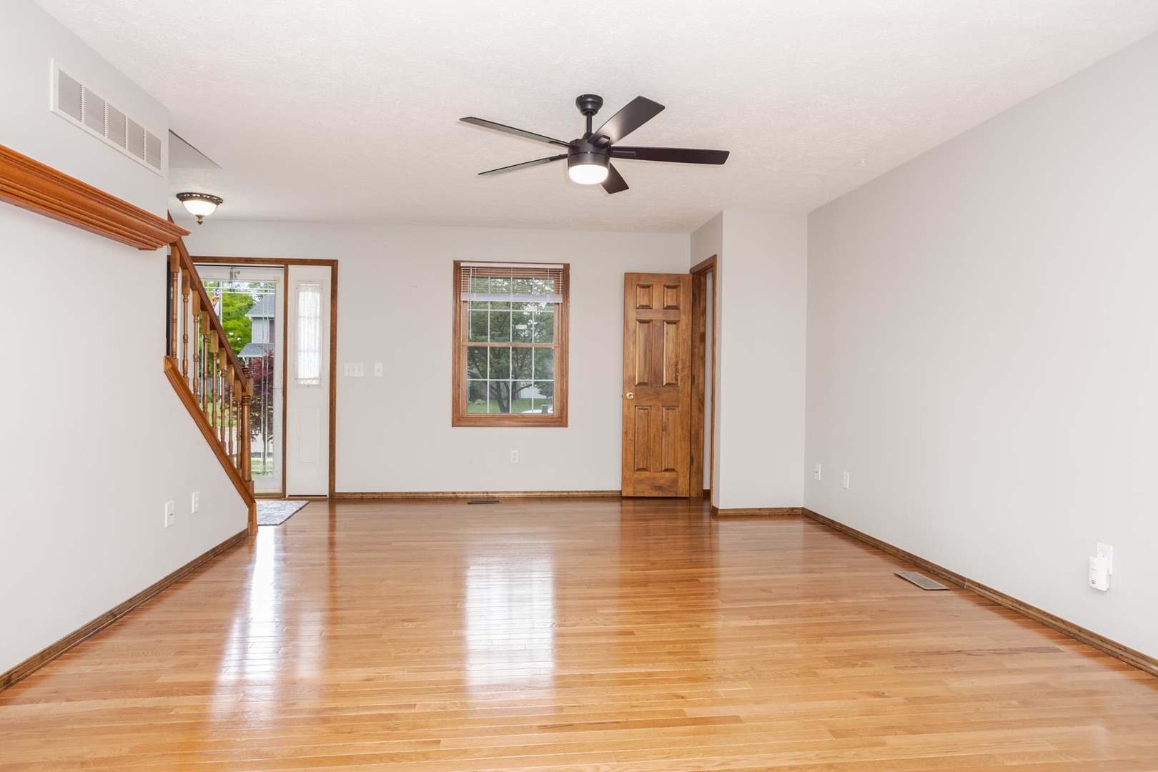 814 Landau Lane Normal, IL 61761 - Photo 12 of 58 a view of an empty room with wooden floor and a window