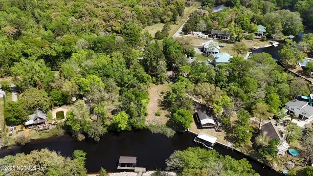 an aerial view of a house with a yard and lake view