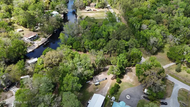 an aerial view of residential houses with outdoor space and trees