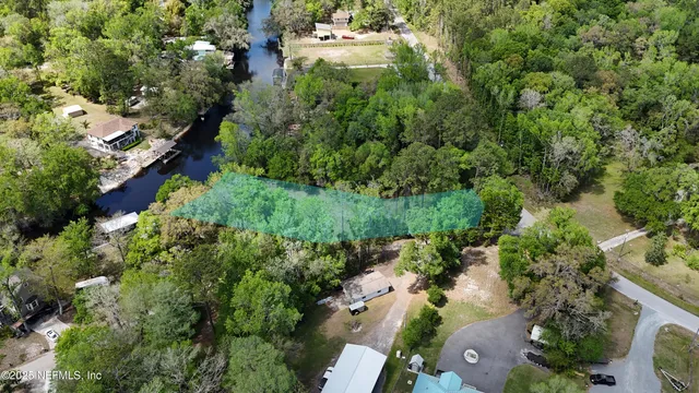 an aerial view of residential houses with outdoor space and trees