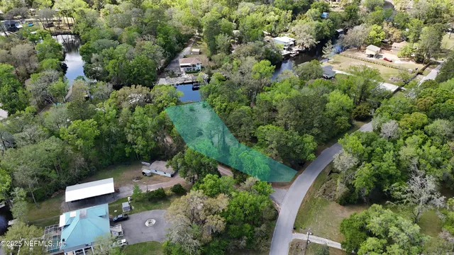 an aerial view of residential house with outdoor space and trees all around