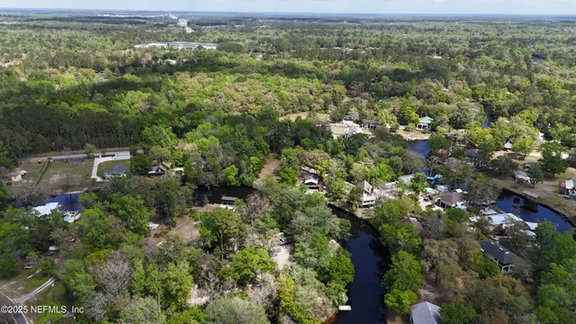 an aerial view of residential houses with outdoor space and trees