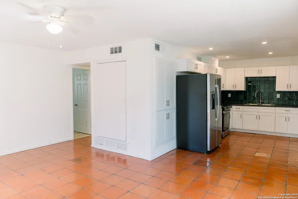 a view of a kitchen with a refrigerator and a stove top oven