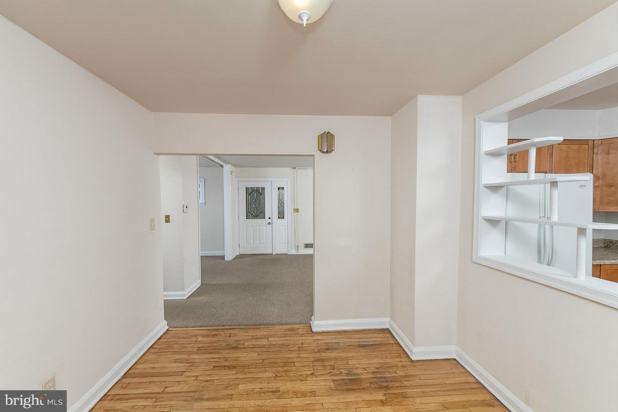6835 Westridge Road Baltimore, MD 21207 - Photo 14 of 30 a view of an empty room with window and wooden floor