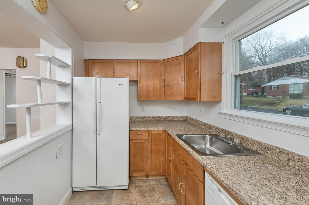 6835 Westridge Road Baltimore, MD 21207 - Photo 8 of 30 a kitchen with a refrigerator a stove and a cabinets with wooden floor