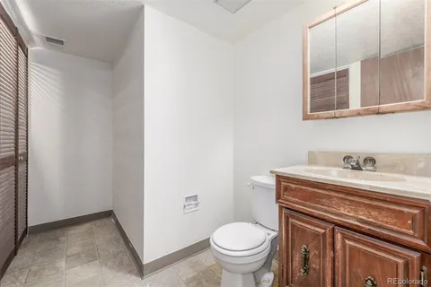 a bathroom with a granite countertop toilet sink and mirror