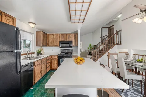 a kitchen with stainless steel appliances a stove a refrigerator and a kitchen island