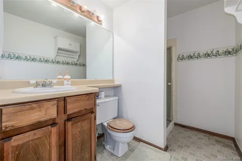 a bathroom with a granite countertop sink toilet a mirror and shower