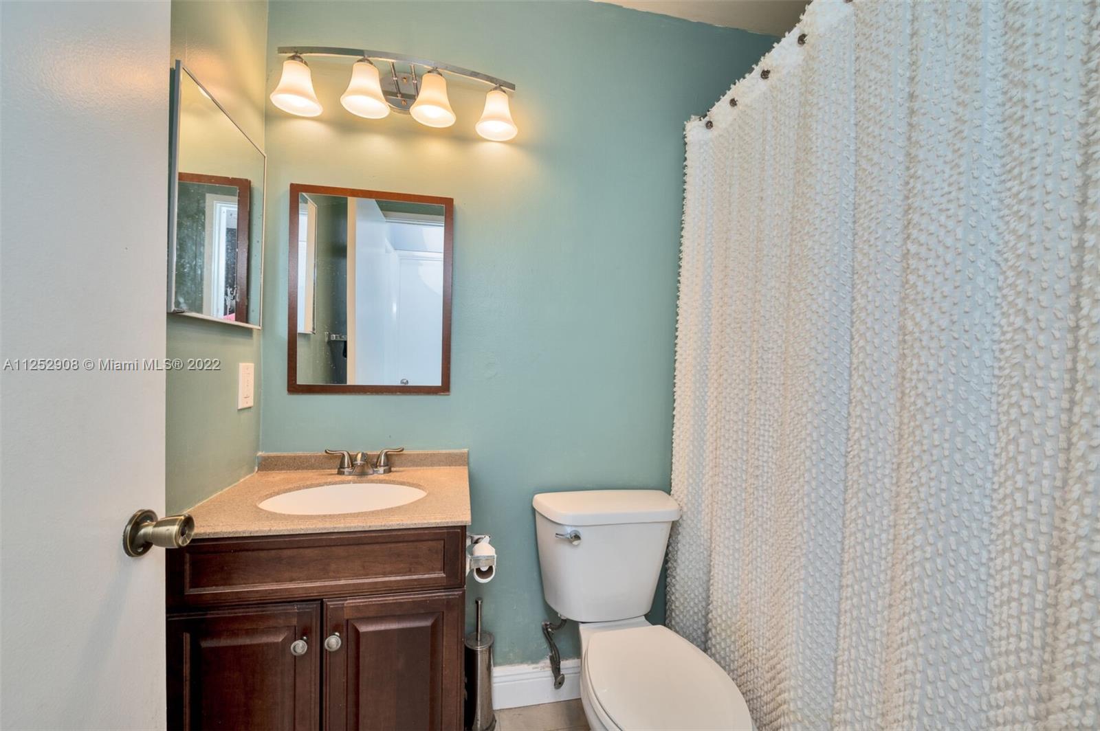 18790 Cloud Lake Circle Boca Raton, FL 33496 - Photo 12 of 27 a bathroom with a toilet a sink and mirror