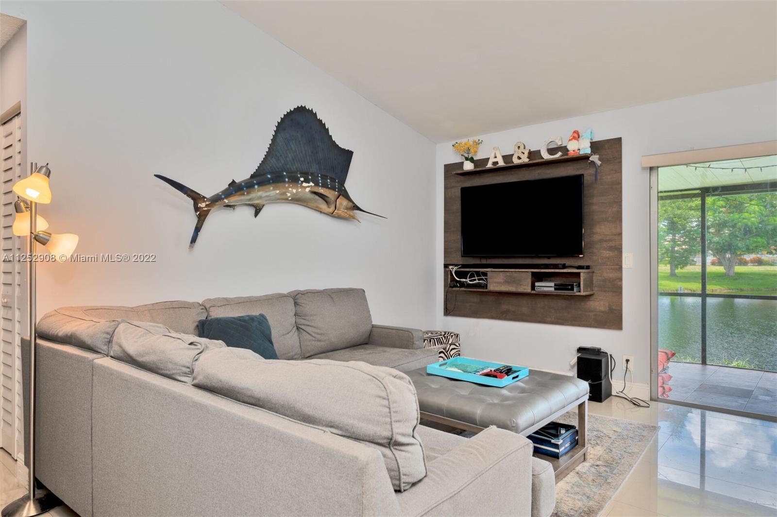 18790 Cloud Lake Circle Boca Raton, FL 33496 - Photo 8 of 27 a living room with furniture and a flat screen tv