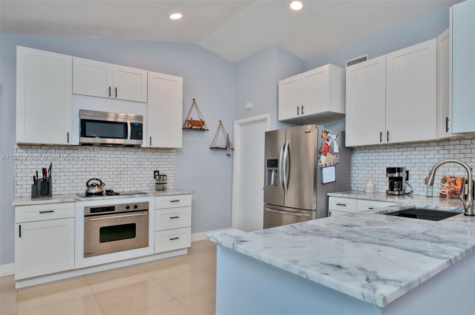18790 Cloud Lake Circle Boca Raton, FL 33496 - Photo 10 of 27 a kitchen with stainless steel appliances granite countertop a refrigerator sink and white cabinets