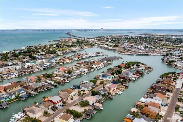 an aerial view of a city with lots of residential buildings and ocean view in back