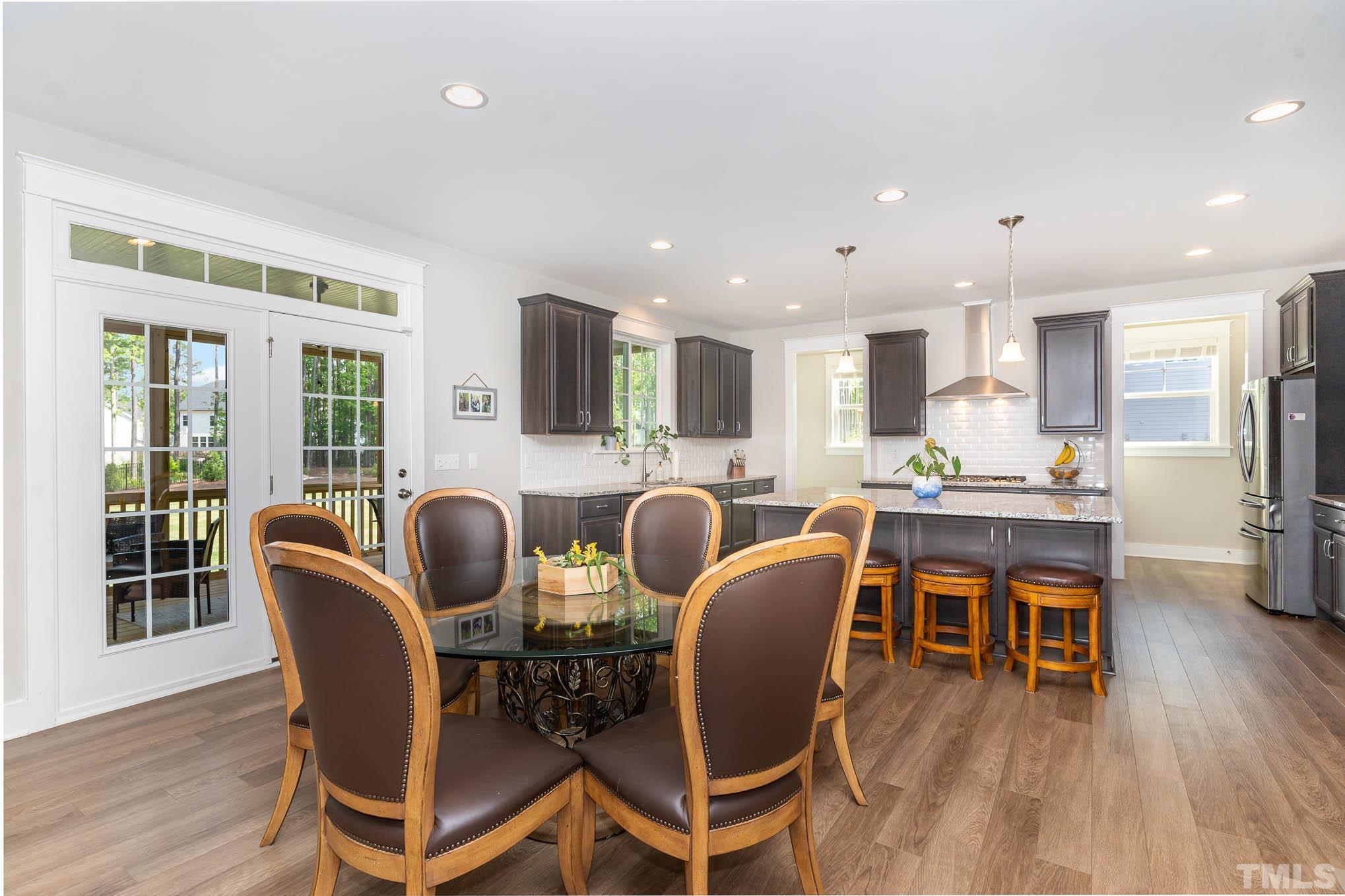 2816 Flume Gate Drive Raleigh, NC 27603 - Photo 14 of 45 a dining room with stainless steel appliances wooden floors a table and chairs