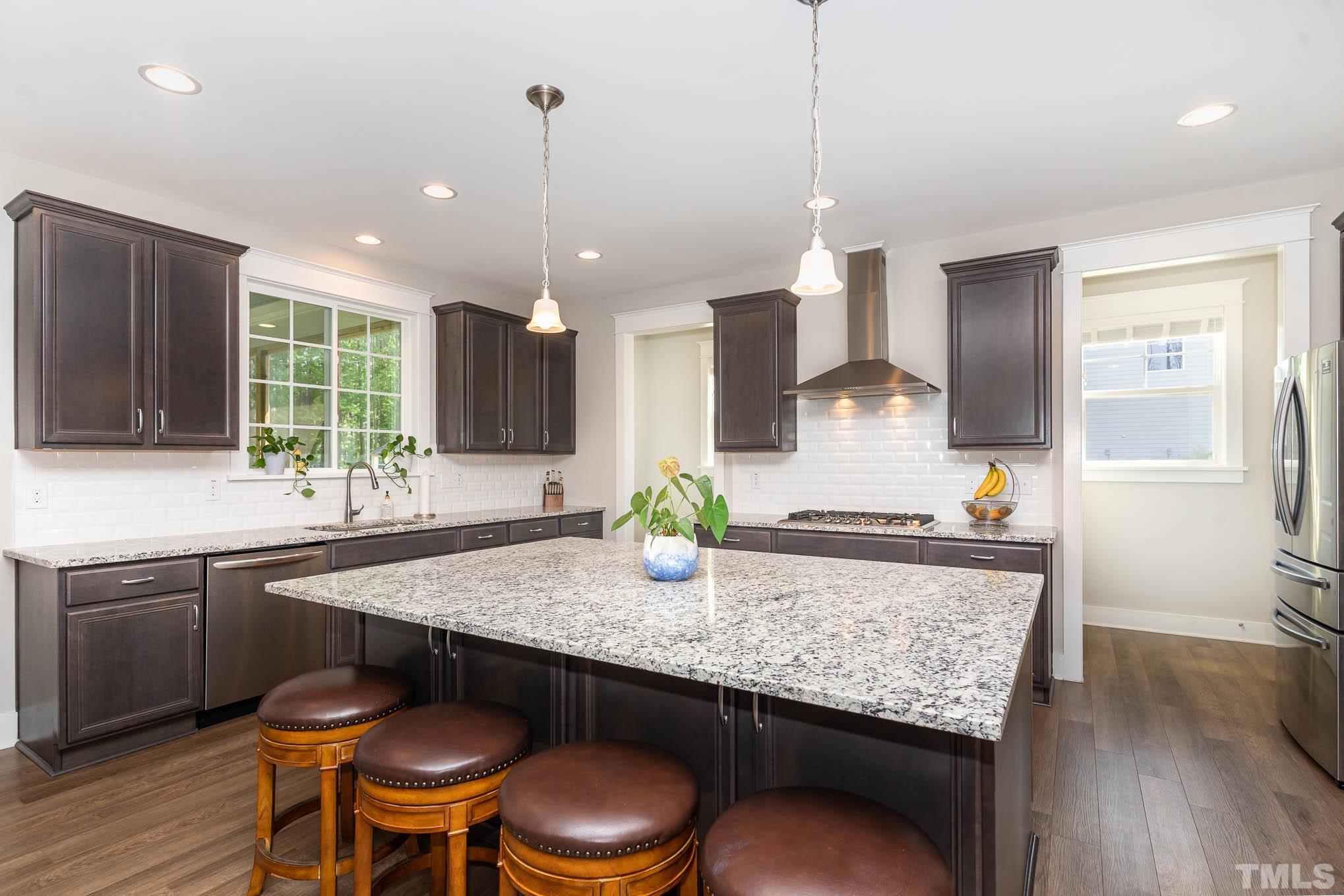 2816 Flume Gate Drive Raleigh, NC 27603 - Photo 16 of 45 a kitchen with granite countertop kitchen island a table and chairs in it