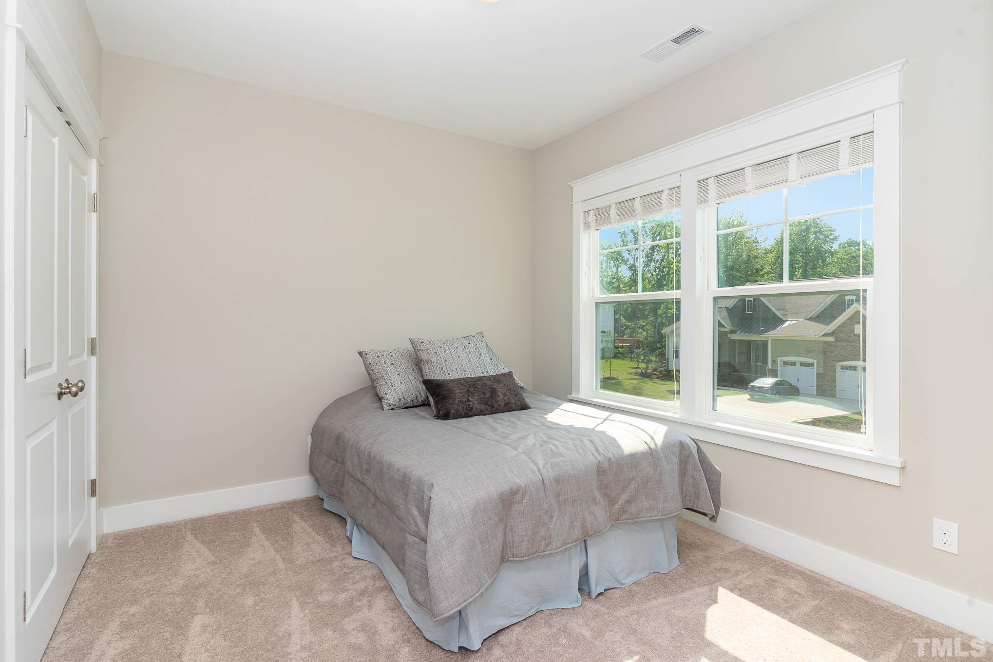 2816 Flume Gate Drive Raleigh, NC 27603 - Photo 23 of 45 a bedroom with a bed and a large window