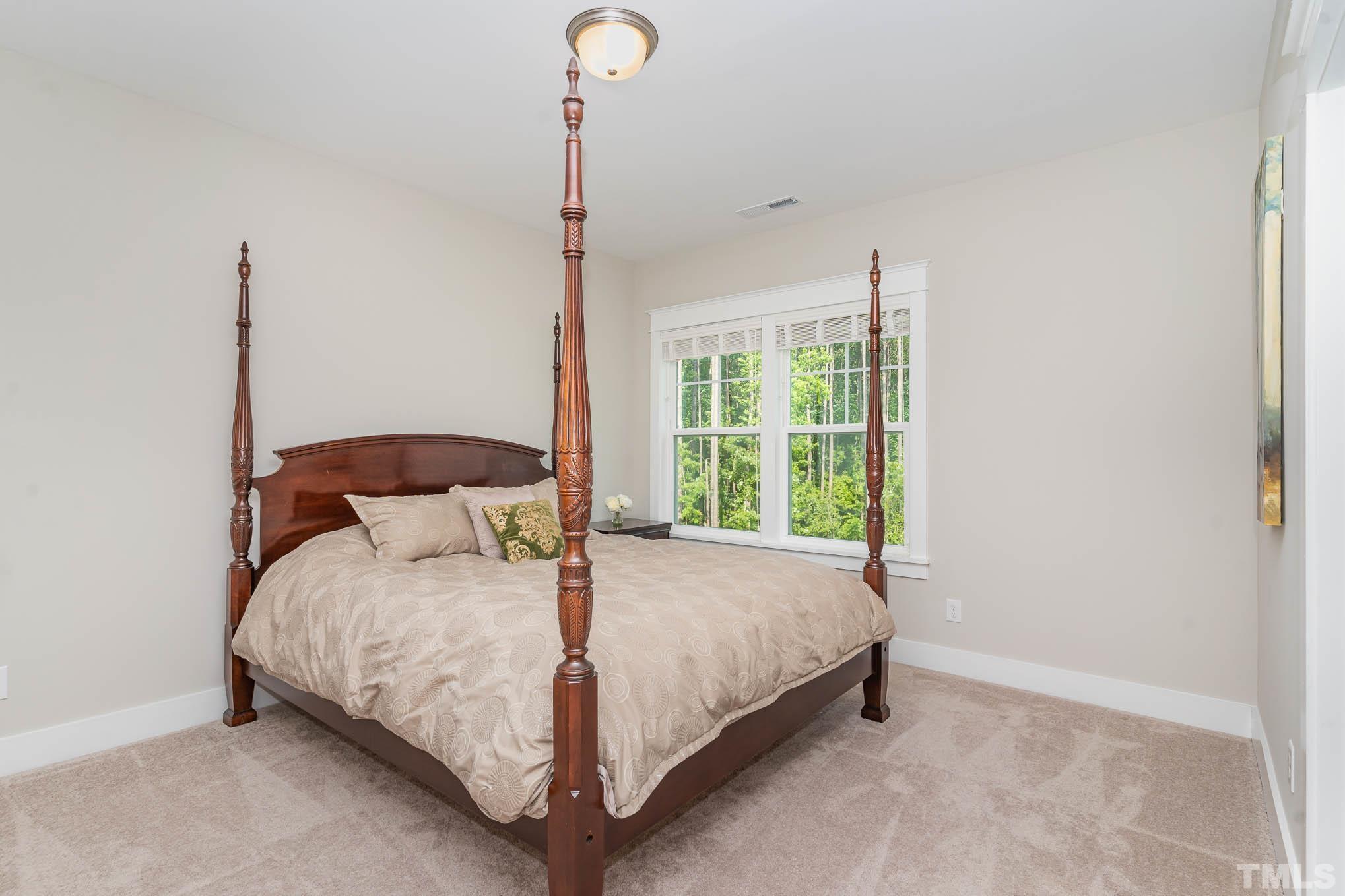 2816 Flume Gate Drive Raleigh, NC 27603 - Photo 26 of 45 a bedroom with a bed lamp and a window