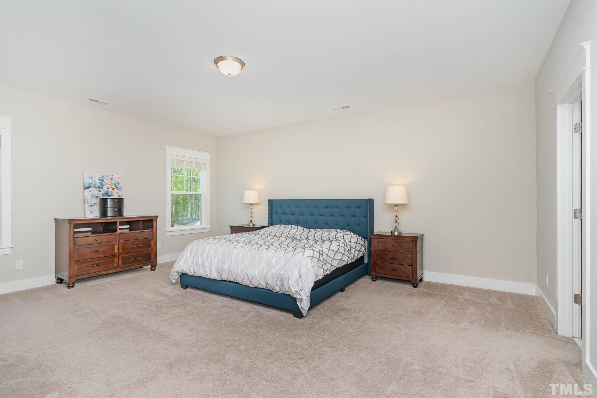 2816 Flume Gate Drive Raleigh, NC 27603 - Photo 28 of 45 a spacious bedroom with a bed and a couch