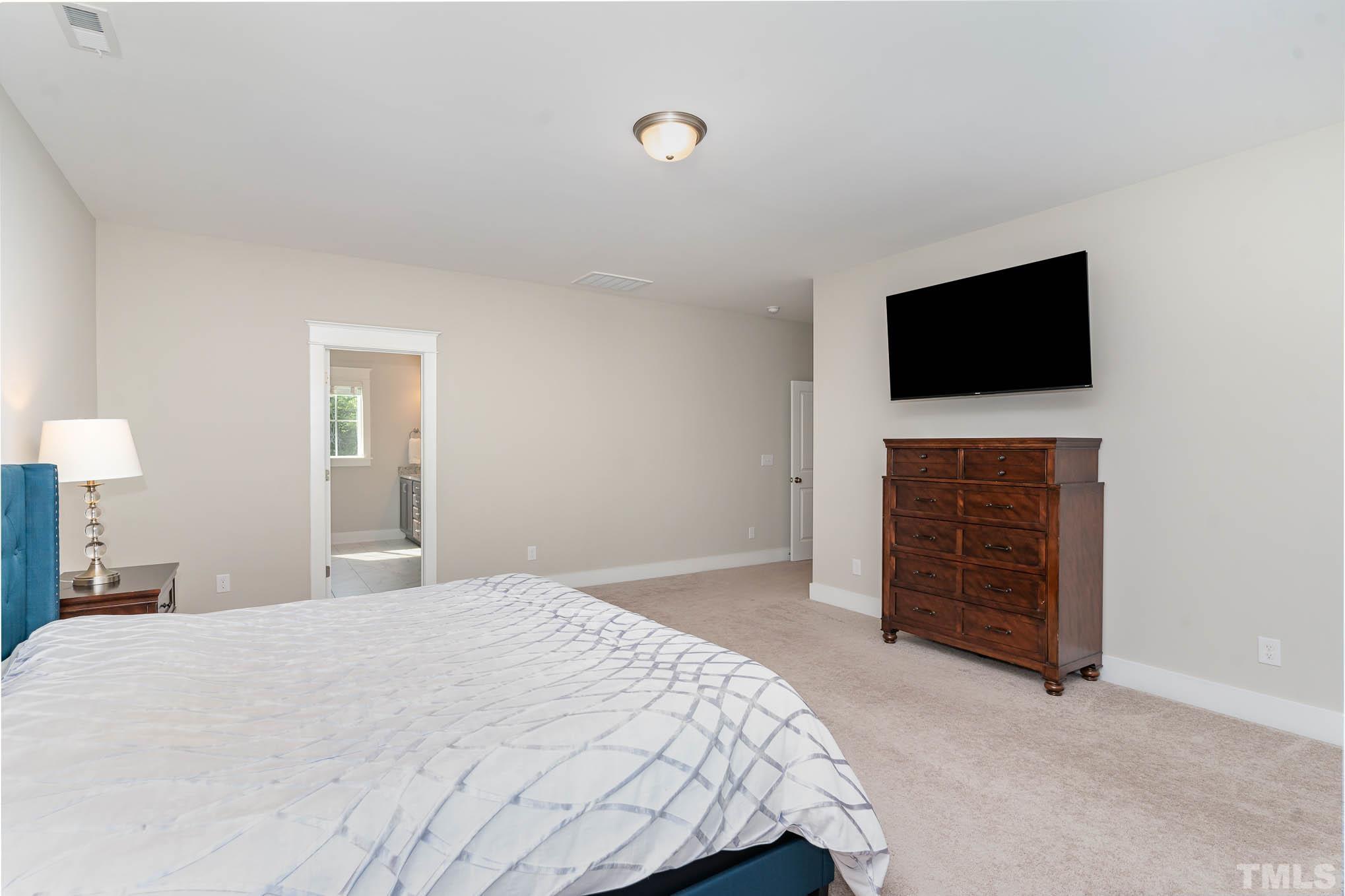 2816 Flume Gate Drive Raleigh, NC 27603 - Photo 29 of 45 a bedroom with a bed and a flat screen tv