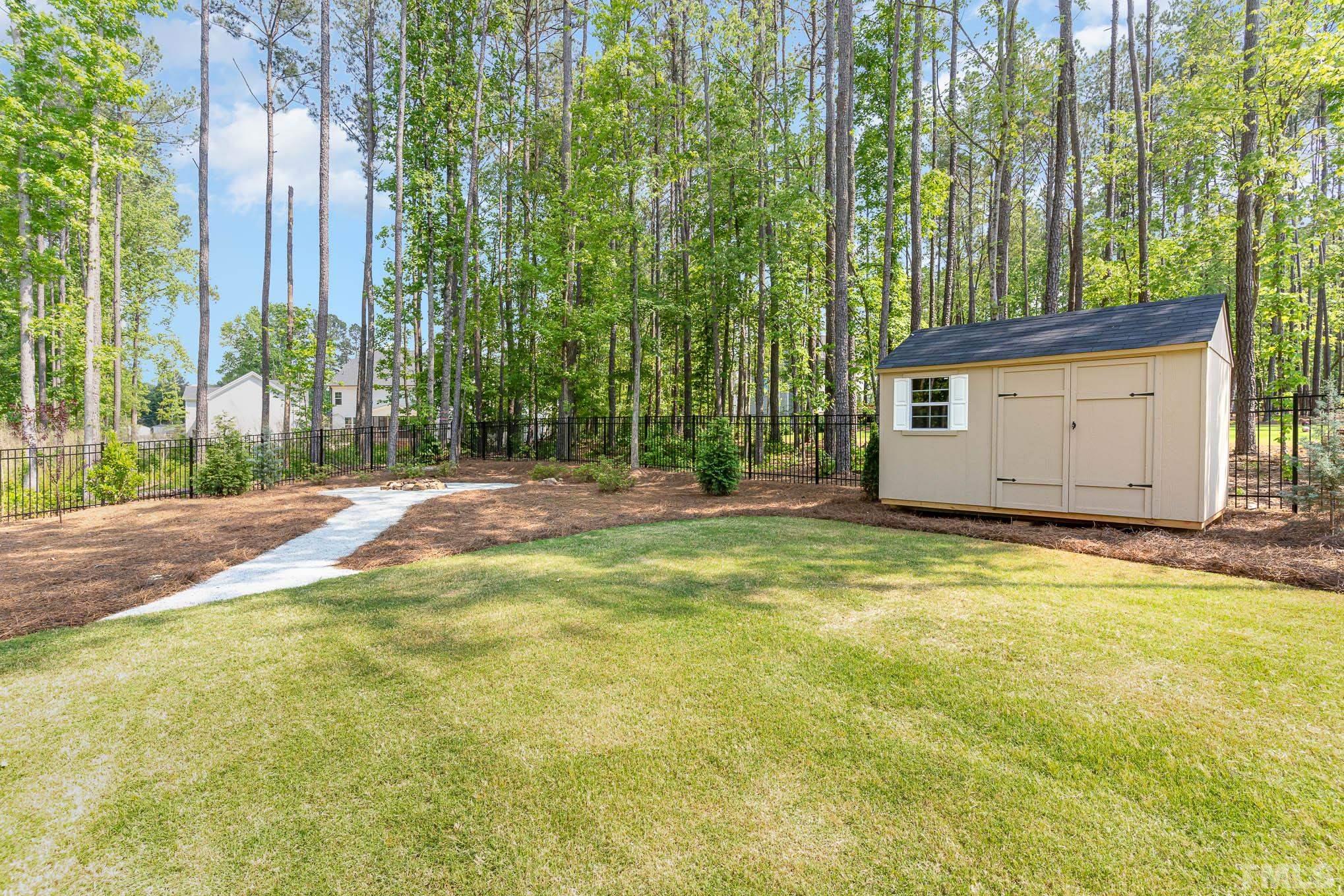 2816 Flume Gate Drive Raleigh, NC 27603 - Photo 37 of 45 a view of a backyard with plants and large trees