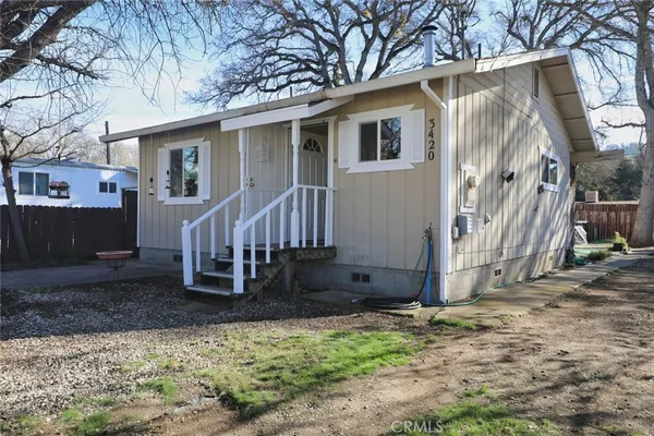 a view of a house with yard and wooden fence