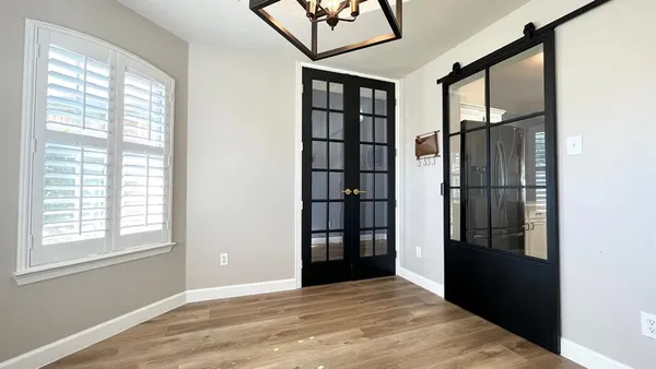 a view of empty room with windows and refrigerator