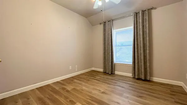 an empty room with wooden floor and closet