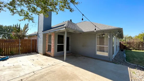 a view of a house with a small yard and wooden fence