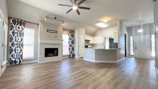 a view of a kitchen with a sink a fireplace and wooden floor