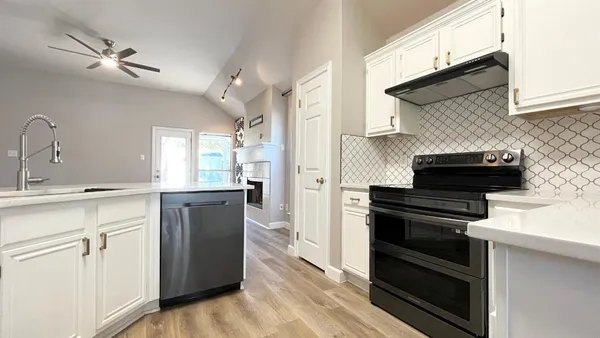 a kitchen with a refrigerator and white cabinets